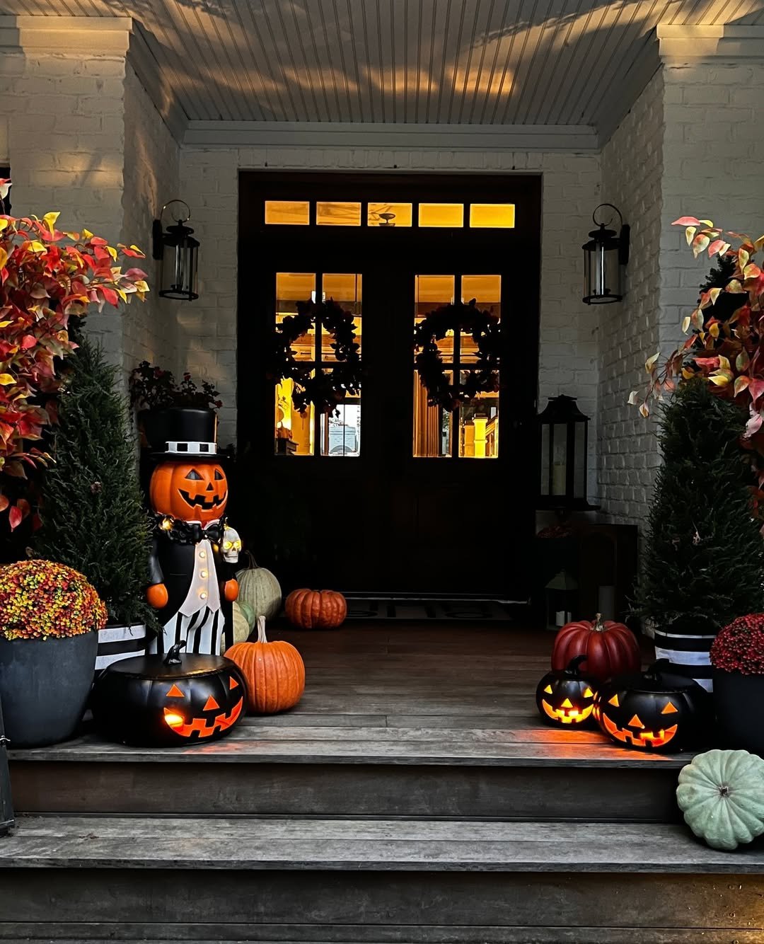 Halloween porch with jack-o'-lantern figure, glowing pumpkins and lanterns, installed by LitUp Vancouver
